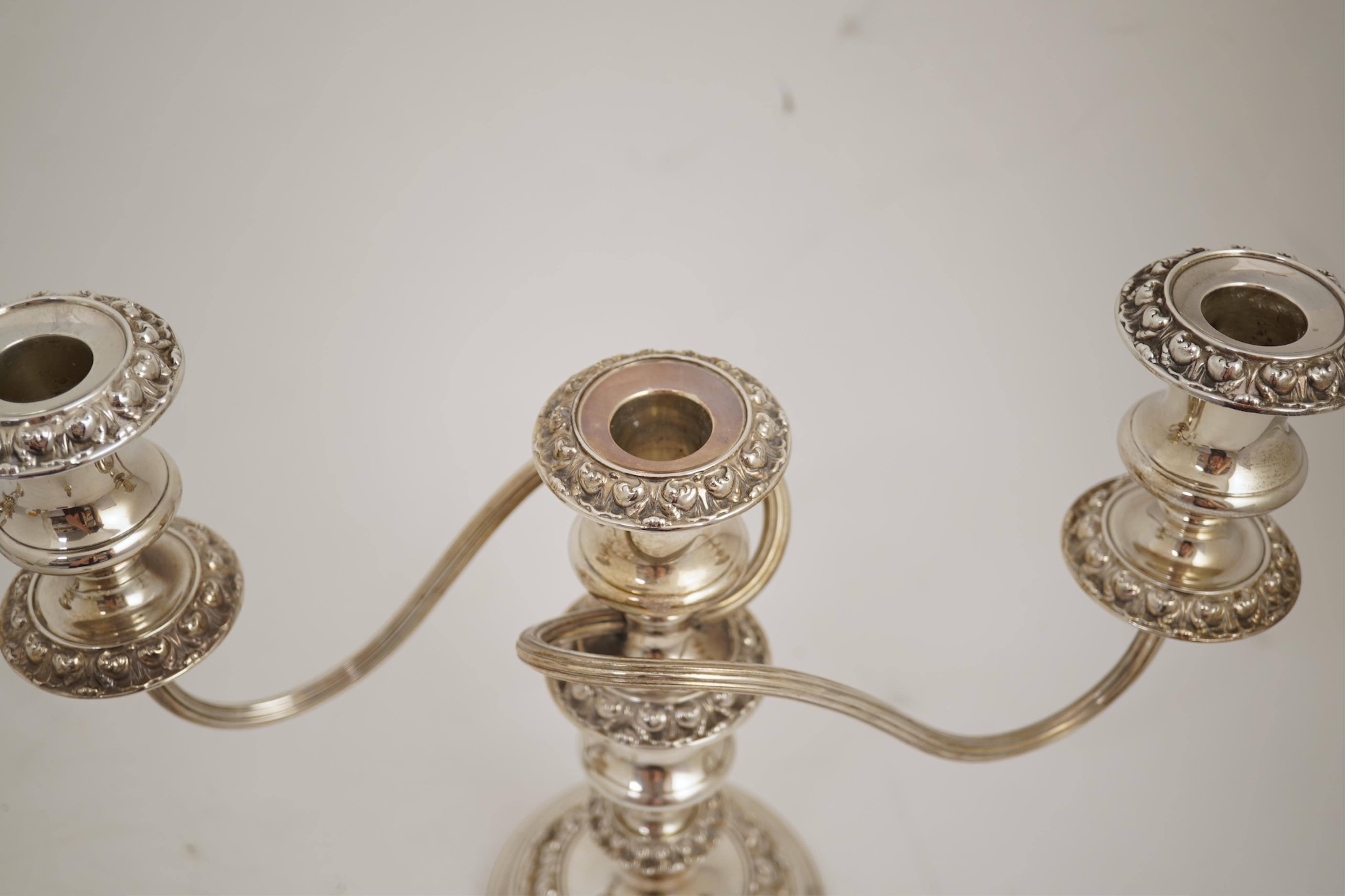 A pair of Elizabeth II silver dwarf two branch, three light candelabra by Barker Brothers Silver Co, with scroll arms and turned knopped stems, Birmingham, 1960, weighted, arms 52oz.